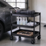 Utility cart with drill case and cleaning supplies next to a car