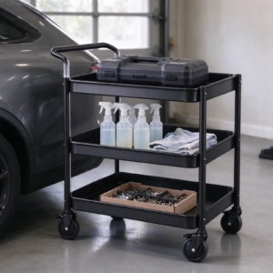 Utility cart with drill case and cleaning supplies next to a car