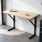 Wall-mounted folding workbench with birch top in a garage